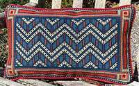 Chevron geometric needlepoint cushion in red, old blues, copper and sand colors